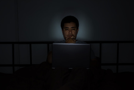 Youngman At Bedroom On Bed Working On Laptopの写真素材
