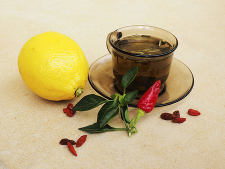 Hot tea for colds, pills and handkerchiefs on table,lemon and peppers, natural remedyの写真素材
