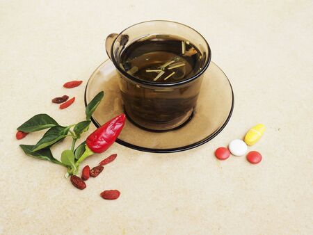 Hot tea for colds, pills and handkerchiefs on table,lemon and peppers, natural remedyの写真素材