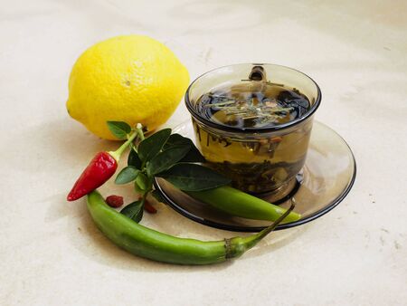 Hot tea for colds, pills and handkerchiefs on table,lemon and peppers, natural remedyの写真素材