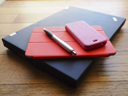 laptop, phone and tablet pc on wooden deskの写真素材