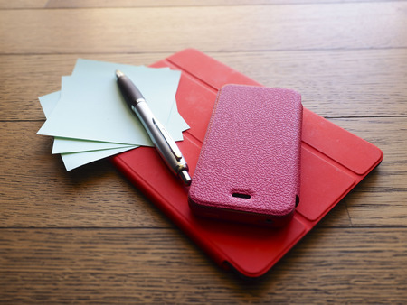 phone and tablet pc on wooden deskの写真素材