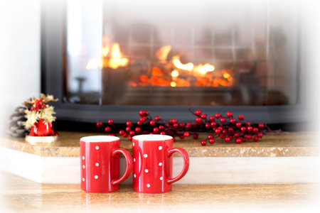Red cup over fireplace on wooden table. Winter and Christmas holiday conceptの写真素材