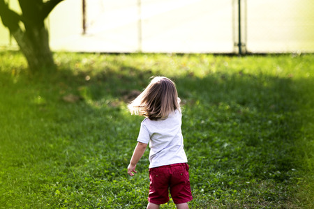 Happy child in spring field. Young girl relax outdoors. Freedom conceptの写真素材
