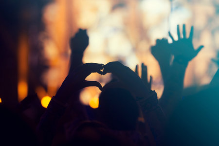 crowd, happy people enjoying rock concert, raised up handsの写真素材