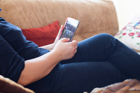Elderly woman relaxing in bed with a tabletの写真素材