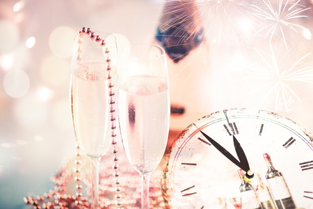 New Year champagne glasses with fireworks and clockの写真素材