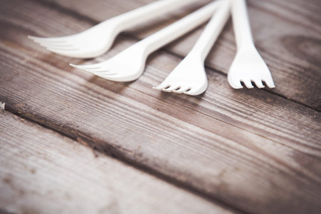Plastic forks on wooden background,  plastic free concept