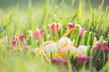 Easter eggs in a basket in the grassの写真素材