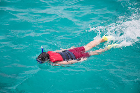 Snorkeling tourist in clear blue water paradise