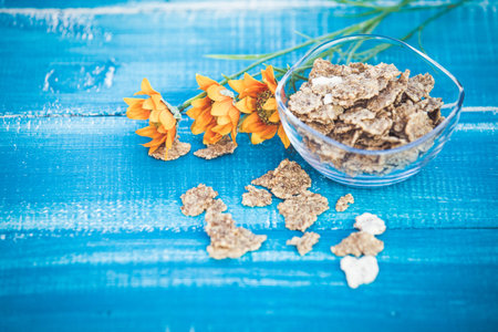 Organic cereal and forest berries on blue wooden background
