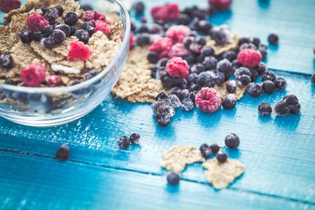 Organic cereal and forest berries on blue wooden backgroundの写真素材