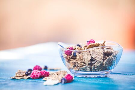 Organic cereal and forest berries on blue wooden backgroundの写真素材