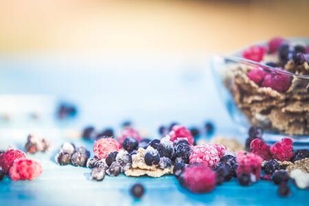 Organic cereal and forest berries on blue wooden backgroundの写真素材