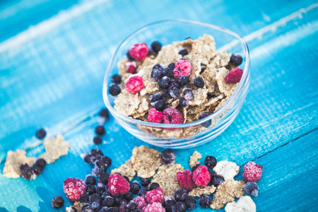 Organic cereal and forest berries on blue wooden backgroundの写真素材