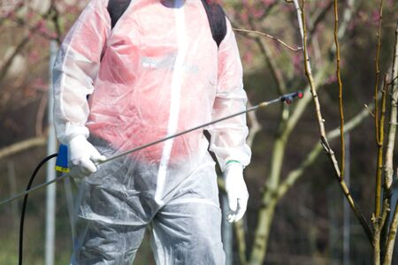 Coronavirus disinfection. Worker in hazmat making disinfection in public parkの写真素材