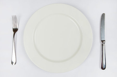 Photo of the fork and knife with white plate on white background