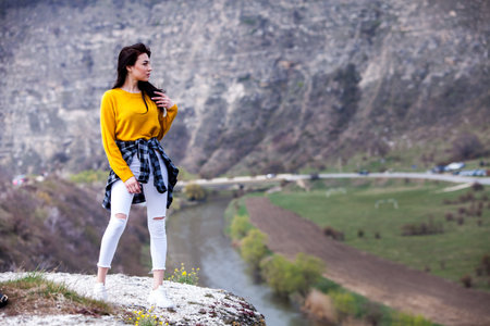 A young traveler girl sit on the top of valley. Young girl love wild life, travel, freedom. Woman...