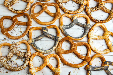 Fresh prepared homemade soft pretzels. Different types of baked bagels with seeds on a black...