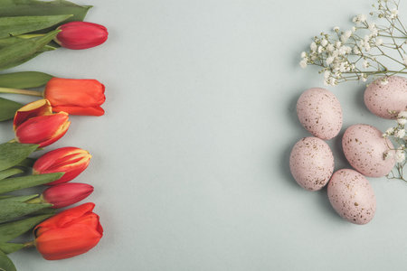 Colorful Easter eggs in basket on wooden background, flat lay. Space for textの写真素材