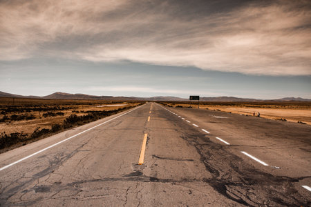 Road in the desert with cloudy sky in the background, Namibiaの写真素材