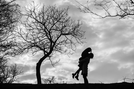 Silhouette of a mother and daughter walking in the park.の写真素材