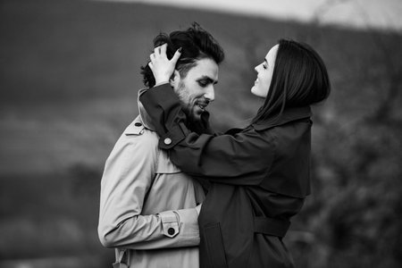 Beautiful couple spend time together outdoor. Man and woman in trench coat.