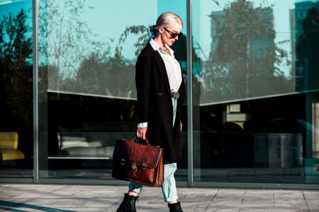 Fashionable mature man with a leather briefcase in the cityの写真素材