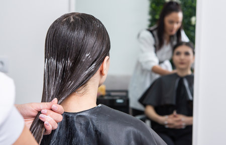 Professional hairdresser washing hair of woman client in beauty salonの写真素材