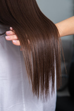 Close-up of a woman's long brown hair in a beauty salonの写真素材