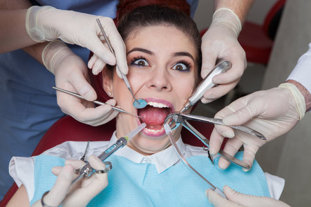 Dentist with assistant and patient at dental clinic. Dentistryの写真素材