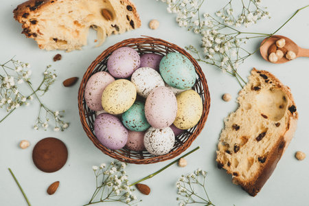Easter eggs in a basket on a light blue background, top view