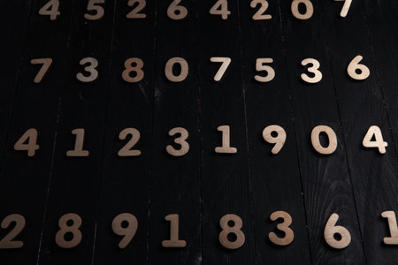 Wooden numbers on a black wooden background. Numbers from zero to nine.の写真素材