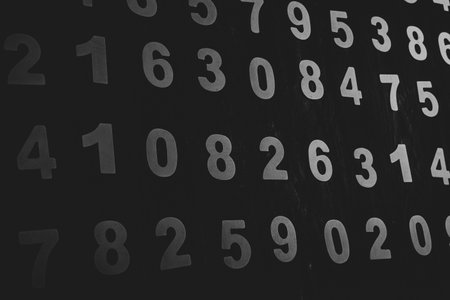 Black and white numbers on a blackboard. Abstract background for design.の写真素材
