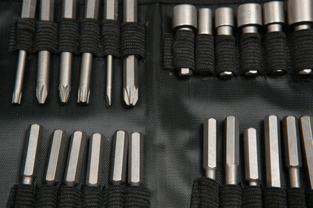 Set of metal screwdriver bits in a black case close-up