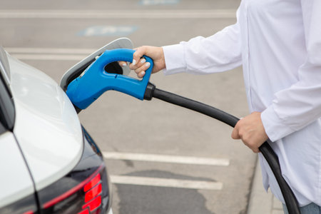 Close-up of a man refueling a car at a gas stationの写真素材