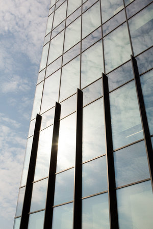 Reflection of sky in windows of modern office building. Business background