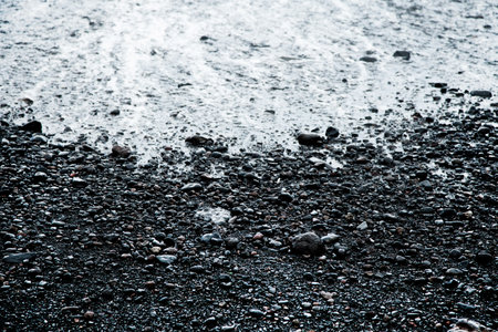 Pebbles on a black sand beach in Iceland. Toned.の写真素材