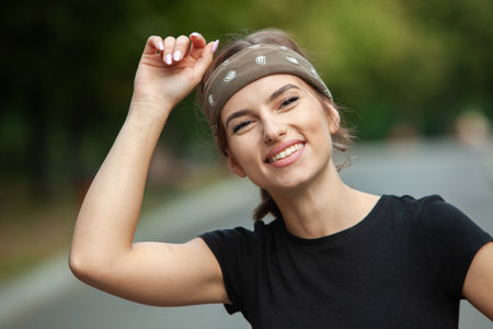 Portrait of a beautiful young woman in a black t-shirt and bandanaの写真素材