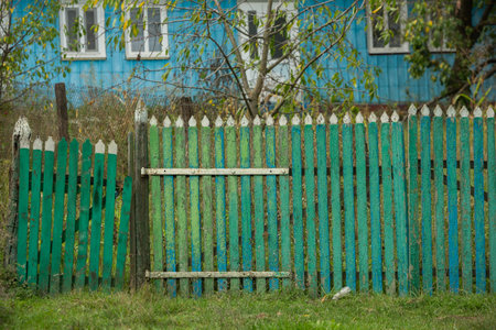 Old wooden fence in the yard of a country house. Green fence.の写真素材