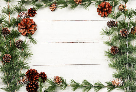 Christmas background with pine cones and branches on white wooden planks.の写真素材