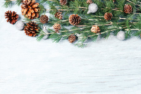 Christmas background with fir branches and cones on wooden board. Top view with copy spaceの写真素材