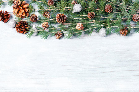 Christmas background with fir branches, cones and snow on white wooden boardの写真素材