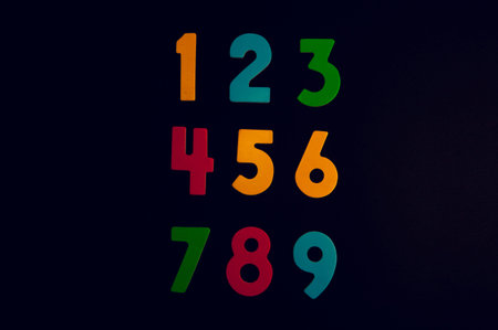 Colorful numbers on a black background. The concept of education.