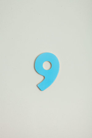 Blue plastic number 9 on white background, business and education concept.