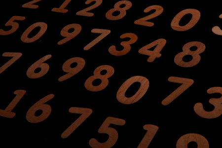 Bunch of wooden numbers on a black background. Close up.の写真素材