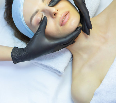 Young woman having a facial massage in a beauty salon. Beauty treatment concept.の写真素材