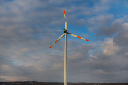 Wind turbine on the background of the blue sky. Clean renewable energy. Electric power production.