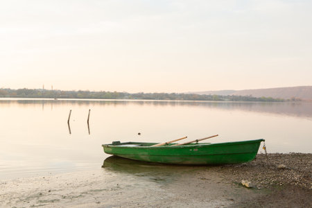 Fishing boat on the bank of the lake in the early morningの写真素材