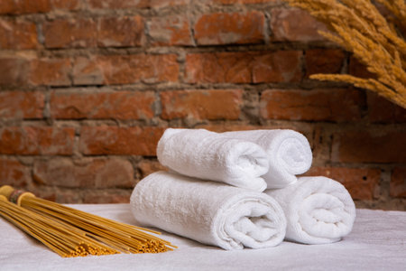 Spa still life with white towels on a background of a brick wallの写真素材